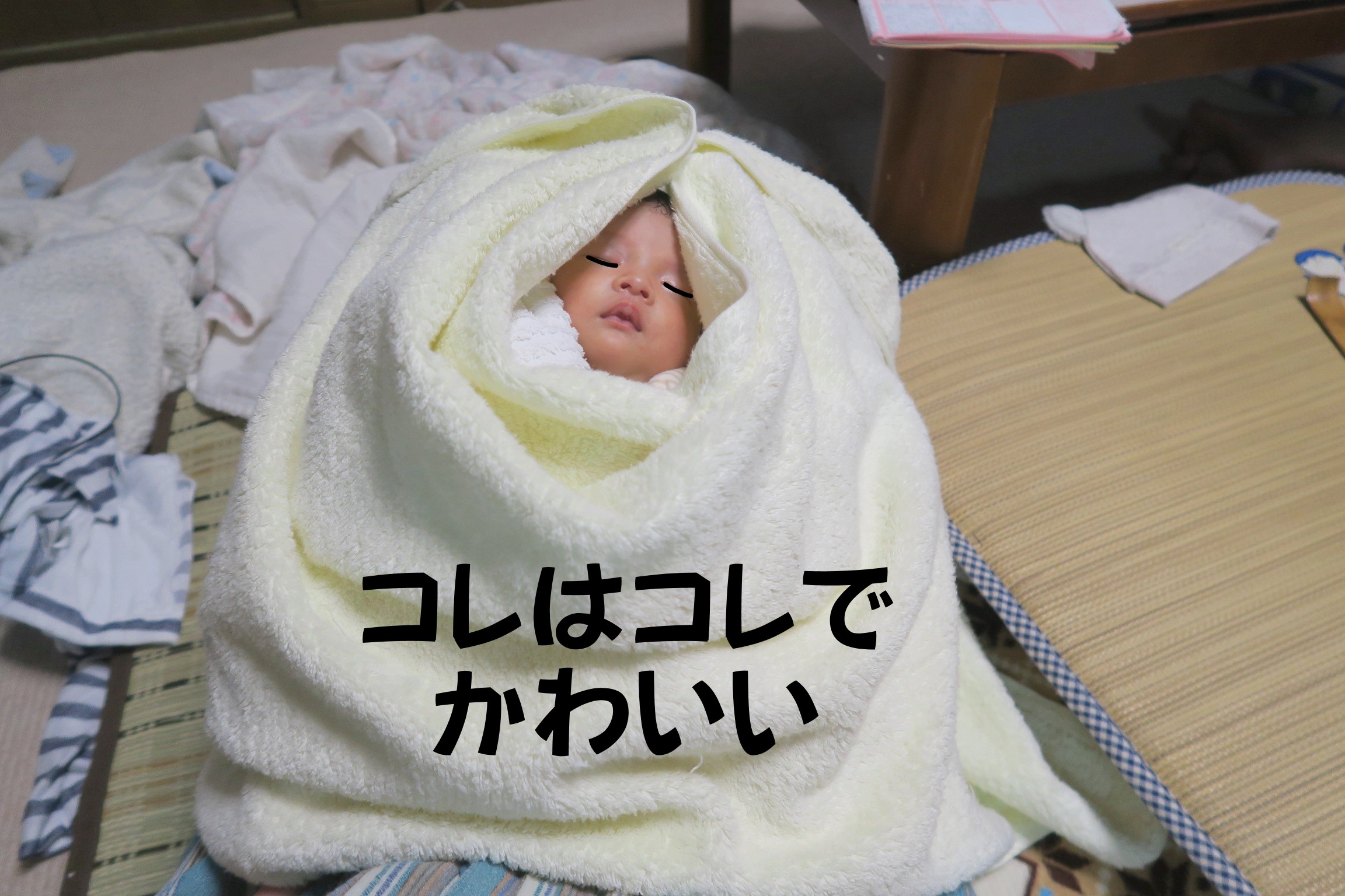 タオルで包まれた新生児の赤ちゃん